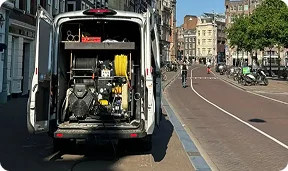 Servicebus van Rioolned aan een gracht